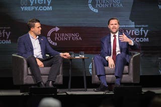 U.S. Vice President JD Vance (R) speaks with Turning Point USA spokesperson Andrew Kolvet during a Turning Point USA event